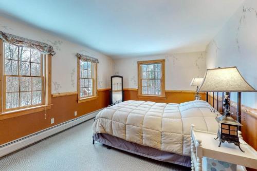 a bedroom with a large bed and windows at Moose Lodge in Newry