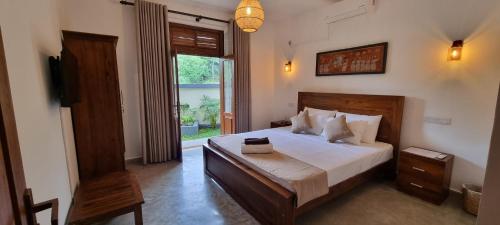 a bedroom with a large bed and a window at Moksha Villa-Hostel Kandy in Kandy