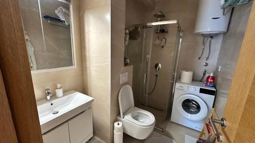 a small bathroom with a toilet and a washing machine at Bella Vista Lux apartment in Baošići