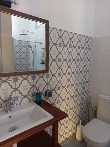 a bathroom with a sink and a toilet and a mirror at Villa Annie in Mythimna