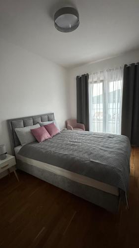 a bedroom with a large bed with pink pillows at Bella Vista Lux apartment in Baošići