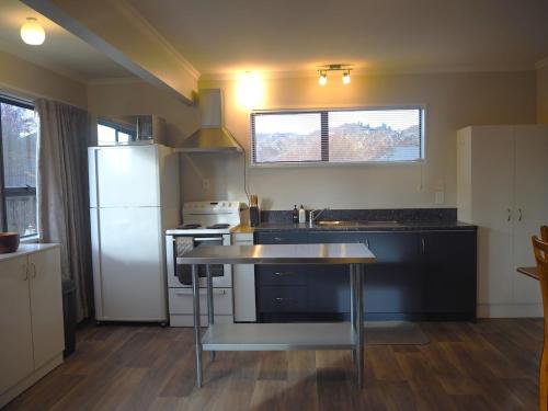 a kitchen with a refrigerator and a table in it at Private Flat in Bridge Hill in Alexandra