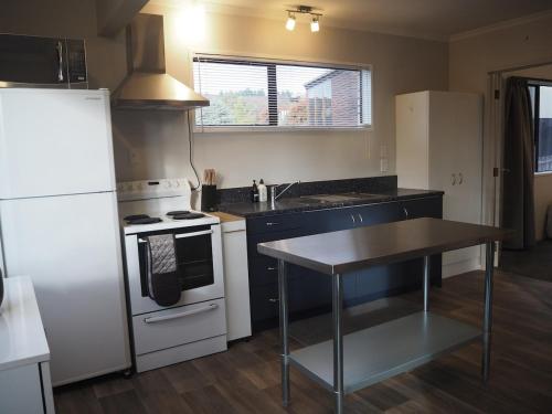 a kitchen with a white refrigerator and a table at Private Flat in Bridge Hill in Alexandra