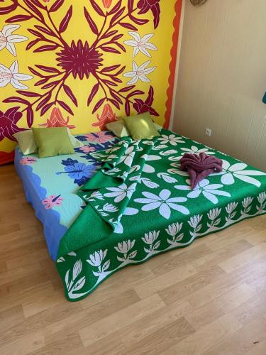 a bed in a room with a colorful wall at Rurutu Randy in Rurutu
