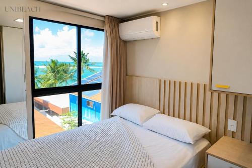 a bedroom with a bed and a view of the ocean at Beachfront flat at Porto de Galinhas beach, close to the natural pools. in Porto De Galinhas