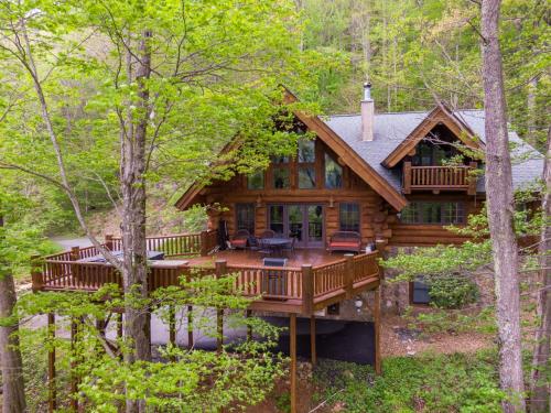 a log home with a deck in the woods at Buffalo Creek Lodge in West Jefferson