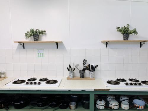 a kitchen with a stove top with pots and utensils at Iluka Retreat Glamping Village & Group Lodge Accommodation in Red Hill South