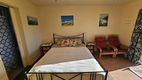 a bedroom with a bed and two chairs at Bahara Accommodation in Springfield