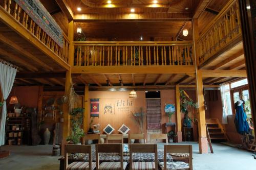 a room with wooden ceilings and chairs and a staircase at Hihi Homestay Tả Van - Mountain View & Local Experience in Sa Pa in Tả Van