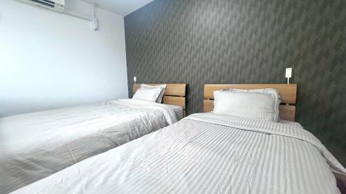 two beds sitting next to each other in a room at Guesthouse Yu in Yomitan