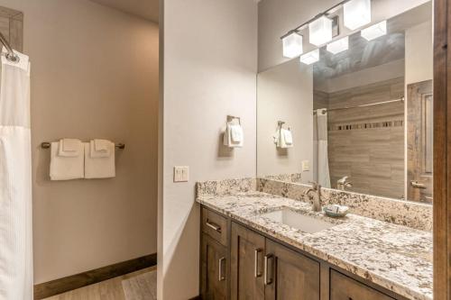 a bathroom with a sink and a large mirror at Tamarack Terrace in Lakeside
