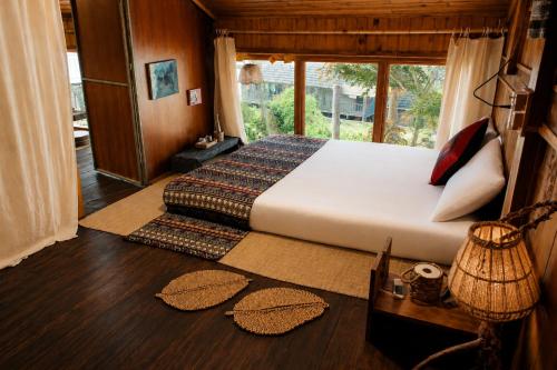 a bedroom with a bed and a large window at Hihi Homestay Tả Van - Mountain View & Local Experience in Sa Pa in Tả Van