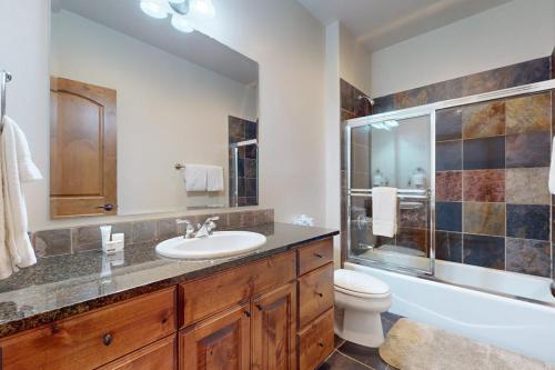 a bathroom with a sink and a toilet and a tub at Big Sky Bliss in Big Sky