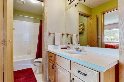 a bathroom with a sink and a toilet and a mirror at Big Horn 19 in Big Sky