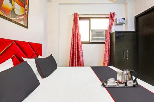 a bedroom with a large bed with a red headboard at Hotel O Ethereal Inn in New Delhi