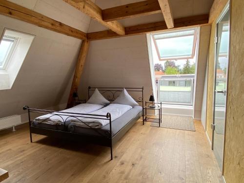 a bedroom with a bed in a room with windows at Hopfengrün Langenthal in Langenthal