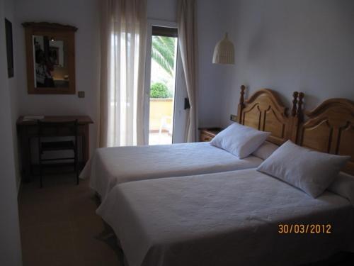a hotel room with two beds and a window at Hotel Antonio in Zahara de los Atunes