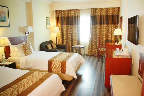 a hotel room with two beds and a chair at Fortune Murali Park, Vijayawada - Member ITC's Hotel Group in Vijayawāda