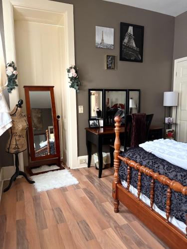a bedroom with a bed and a desk and a mirror at Graystone Manor in Albion