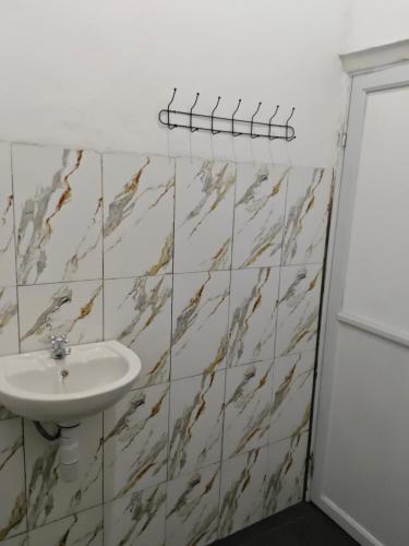 a bathroom with a sink and marble tiles at Snooze hostel lombok in Selong Belanak