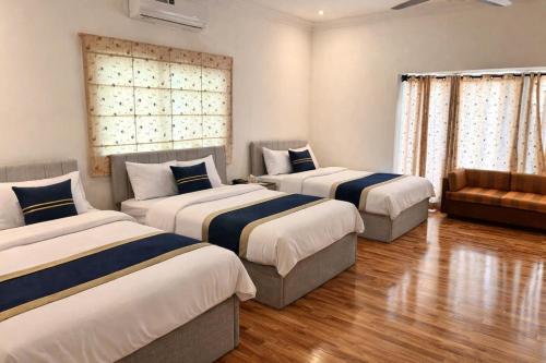 a room with two beds and a couch in it at Sable d'Or Résidence by Star 'A' in Karachi