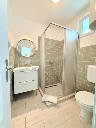 a bathroom with a shower and a sink and a toilet at Helló Zsóry Apartman in Mezőkövesd