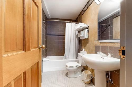 a bathroom with a toilet and a sink and a tub at Shoshone 1965 in Big Sky