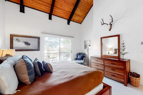 a bedroom with a large bed and a mirror at Ducks Unlimited 173 in Big Sky