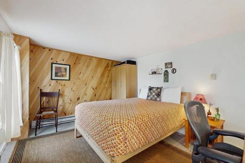 a bedroom with a bed and a chair at The Wolfeboro House in Wolfeboro