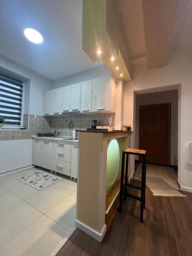 a kitchen with white cabinets and a stool in it at Apartment Slađana i Luna in Subotica