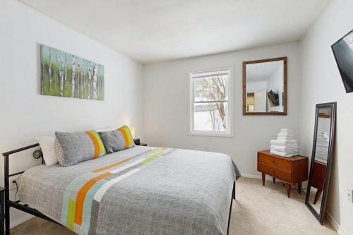 a bedroom with a bed and a mirror and a dresser at Champ's Camp in Colchester