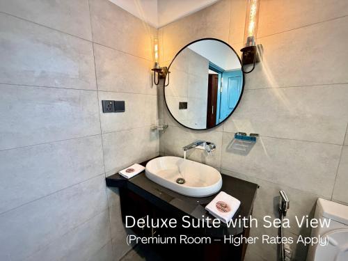 a bathroom with a sink and a mirror at Seashore Mirissa in Mirissa