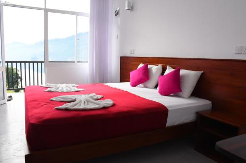 um quarto com uma cama com lençóis vermelhos e almofadas cor-de-rosa em Hatton Summer House em Hatton