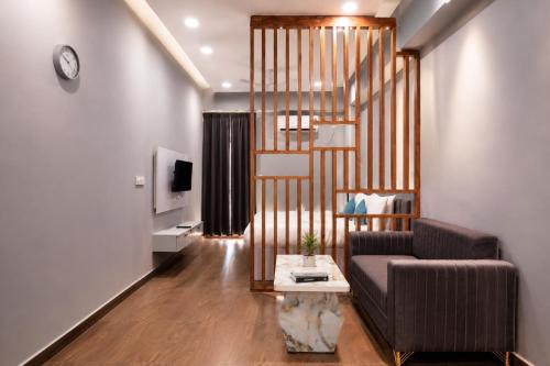a living room with a couch and a spiral staircase at Xenious Smart Suites Greater Noida in Noida