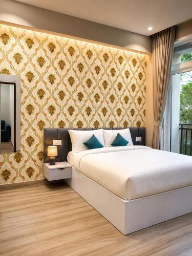 a bedroom with a bed and a wall with a mirror at Xenious Smart Suites Greater Noida in Noida