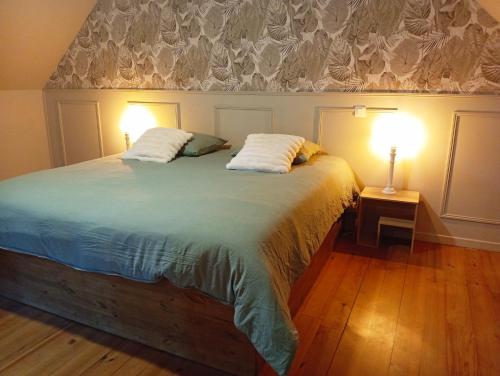 a bedroom with a large bed with two lamps on it at Bienvenue à Longère Bihan - Chambres d'Hôtes - Bed & Breakfast in Plévin