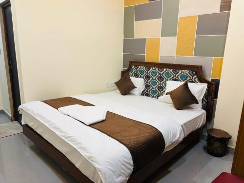 a bedroom with a bed with white sheets and pillows at Hotel sunshine in Kānpur