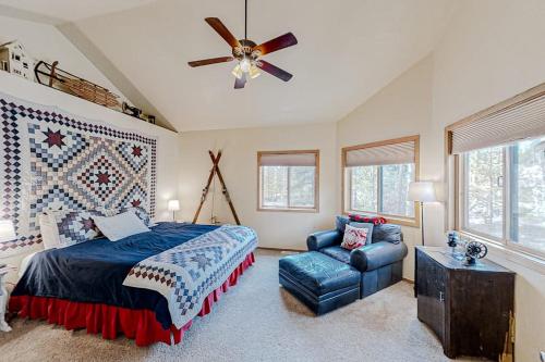 a bedroom with a bed and a couch and a ceiling fan at Hemlock Cabin in Granby
