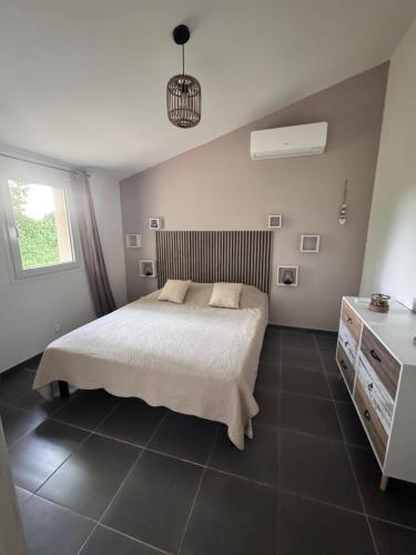 a bedroom with a bed and a dresser and a window at MAZET en CAMPAGNE in Arles