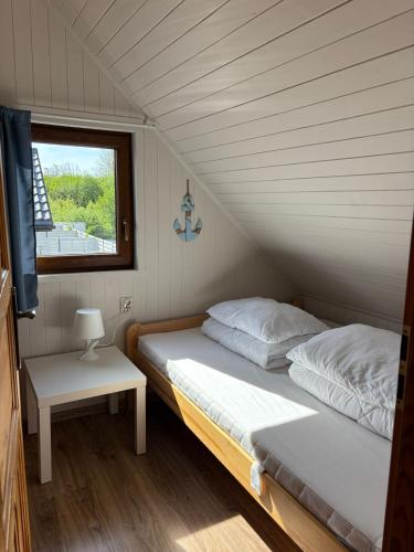 two beds in a room with a window at Promyk in Sarbinowo