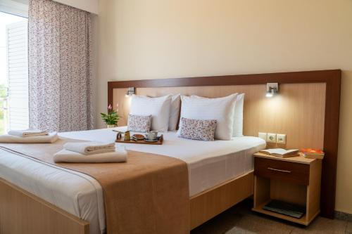 a hotel room with a large bed with towels on it at Arisvi All Seasons Hotel in Skala Kallonis