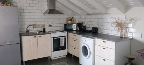 a kitchen with a stove and a washing machine at Studio ISABEL in Sálakos