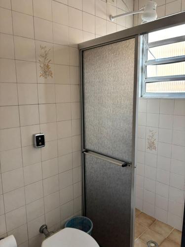 a bathroom with a shower with a toilet and a window at Six's Hotel in Jacareí