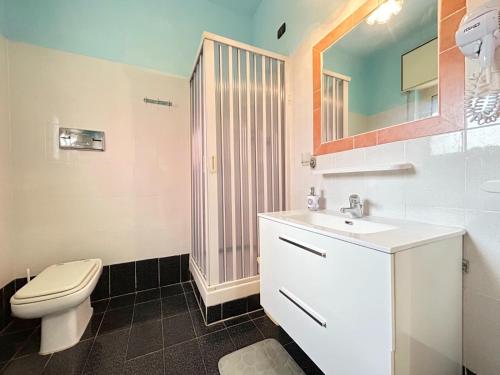 a white bathroom with a toilet and a sink at Pensione Affittacamere Miriam in Scalea