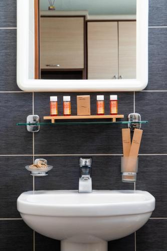 a bathroom with a sink and a mirror at Arisvi All Seasons Hotel in Skala Kallonis