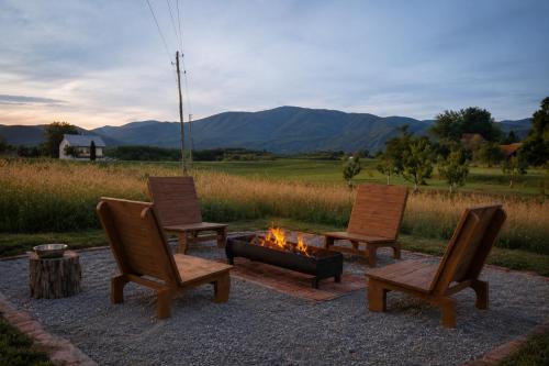 three chairs and a fire pit with mountains in the background at Lakuša Retreat in Latin