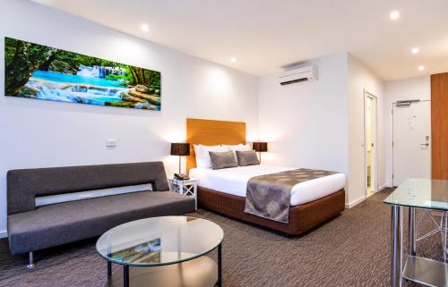 a hotel room with a bed and a couch at Belmercer Motel in Geelong