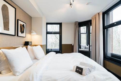 a bedroom with a white bed with a book on it at The Hunfeld in Utrecht