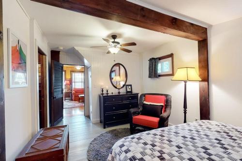a bedroom with a bed and a chair and a mirror at Highland Playhouse in Windham