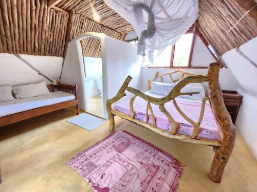 a room with a bed and a rug and a couch at Cave House in Kilifi